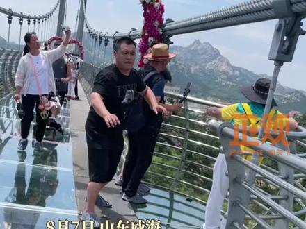 8月7日,山东。男子走玻璃栈道时恐高,紧张的拉紧女儿的小手才敢往前走。网友:看得出大哥是真的害怕,不像演的。