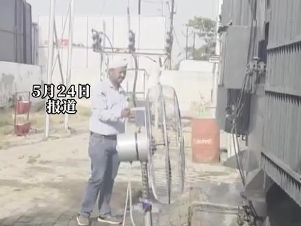 极端热浪下印度电工往过热的变压器上浇水,用电风扇进行冷却