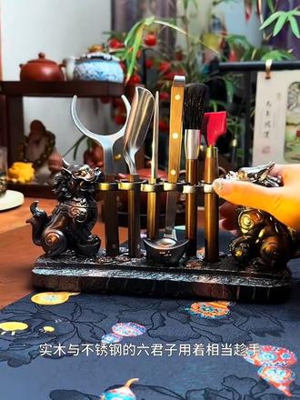 泡茶离不开茶道六君子,这款公母貔貅的底托特别霸气,有着聚财纳福的好寓意,实木与不锈钢的六君子用着相当趁手!茶则取茶叶干净利索,茶托端茶杯防烫还稳妥,茶夹温杯烫盏很方便,茶针开茶饼不伤手,每个茶具都有妙用,中间这里还可放手机,讲究的茶友都会备一套,不仅让茶道发挥出它独有的仪式感,也让喝茶的心境得到升华,很是不错!#茶道六君子 #茶道六君子套装 #泡茶工具 #茶具 #召唤茶友