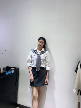 这套穿搭简约又不失精致感~上身是经典白衬衫,干净利落,搭配的灰色系结针织小披肩,为整体增添了几分温柔与层次感,打破了白衬衫的单调。下身搭配一条灰色短裙,利落有型,能很好地展现腿部线条。整体风格既适合日常出街,也能在一些稍正式的场合轻松驾驭,是打造简约时尚造型的不错选择。#服装