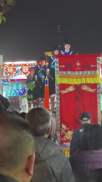 @环联夜市的高跷表演,一面锦绣旗子开路,仪式感拉满。后面是整齐的高跷队员,随着摇摇摆摆,浩浩荡荡,逶迤而至。