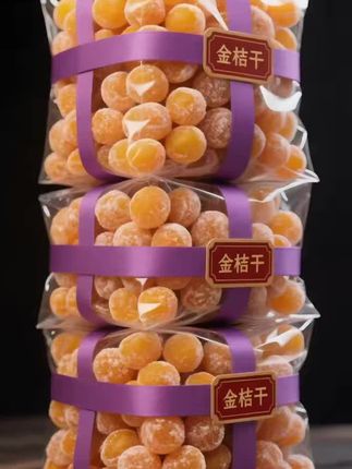 宝子们,谁懂啊!一看到这金桔干,眼睛都要被那暖融融的橙黄色勾住啦~透明包装袋里,一颗颗金桔干圆滚滚、胖嘟嘟的,裹着薄薄一层糖霜,像撒了细碎星光,透着诱人的光泽。紫色丝带交叉缠绕,衬得金桔干愈发鲜亮,还带着“金桔干”的标签,精致感直接拉满。 这金桔干品质真的没话说,每一颗都饱满紧实,一看就是精心挑选的好果子制成。口感更是绝,入口带着恰到好处的酸甜,金桔的清香在嘴里慢慢散开,细细咀嚼,果肉柔韧有嚼劲,甜而不腻,越吃越上头。而且这种包装,密封性好,能很好地锁住金桔干的风味和干爽,不管是平时当作解馋小零食,还是泡茶时丢几颗进去增添风味,都超合适~#甘草金桔干 #快来一起尝个鲜 #大人孩子都爱吃 #超便宜超划算 #金桔@抖加🔥上热门🔥dou+🔥热点宝 @DOU+上热门